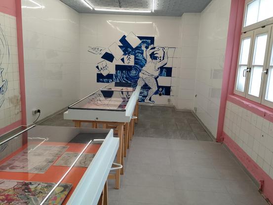 Blick in die Ausstellung Fleischeslust mit großem Bild auf Fliesen im Hintergrund