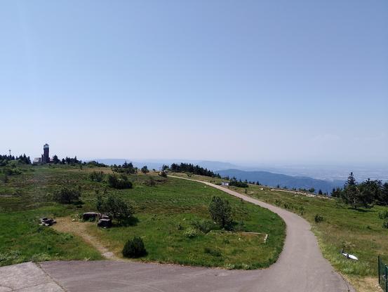 Blick vom Aussichtsturm auf dem Gipfel zum anderen Turm. Rechts der Oberrheingraben. Ganz hinten als fahler grauer Schatten die Vogesen.